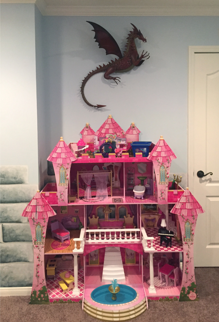 The bedroom decorated with a toy castle and dragon.