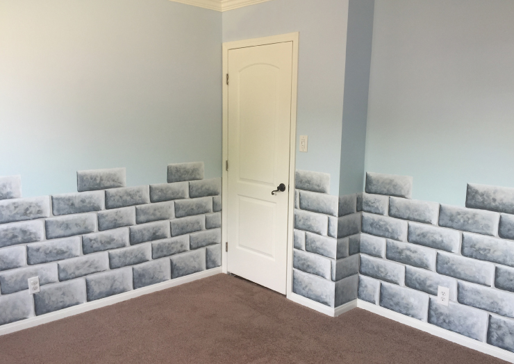 A room with walls that are painted to look like a castle wall.