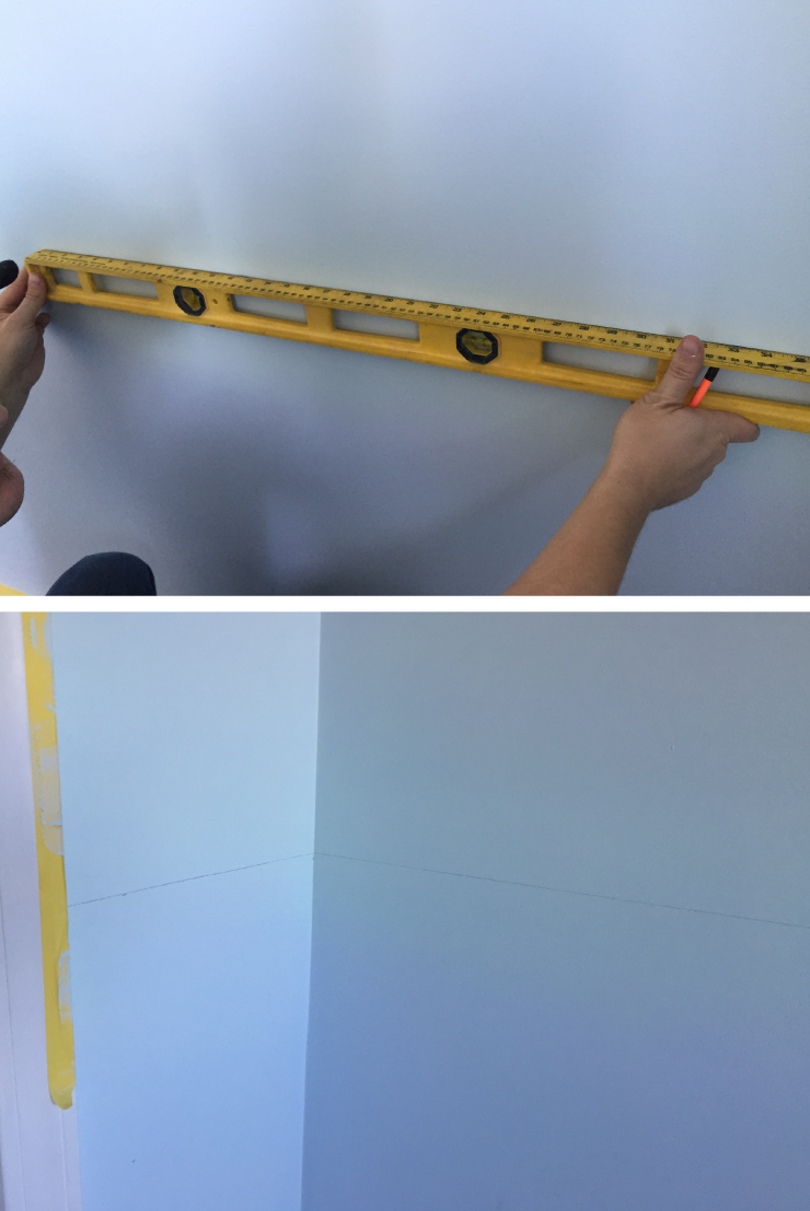 Using a leveler and ruler to measure and tape off wall.