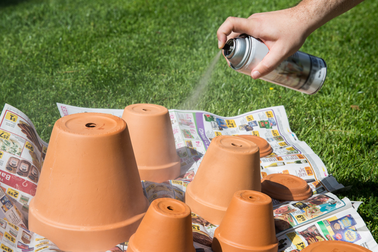 Spraying a sealer onto the clay pots.