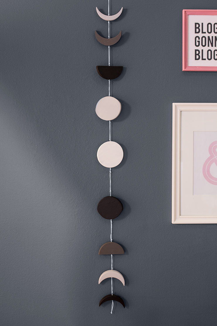 The moon phase mobile completed and hanging on a wall.