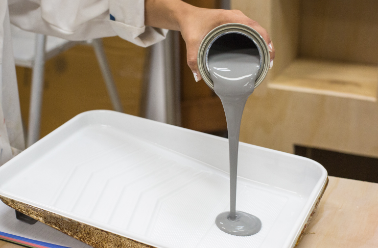 Pouring gray paint into paint tray.