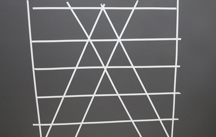 Adding painter's tape on the wall in the shape of the geometric pattern.