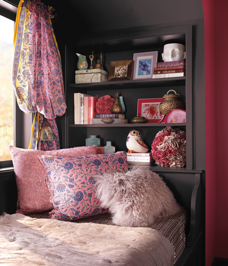 A bedroom decorated with pink and red accents. The wall is painted in Black Garnet.