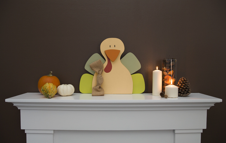 Mantel decorated with a wood painted turkey.