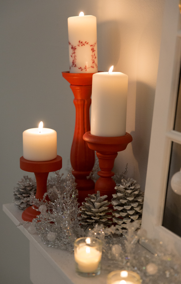 Lit candles placed on red candle holders.