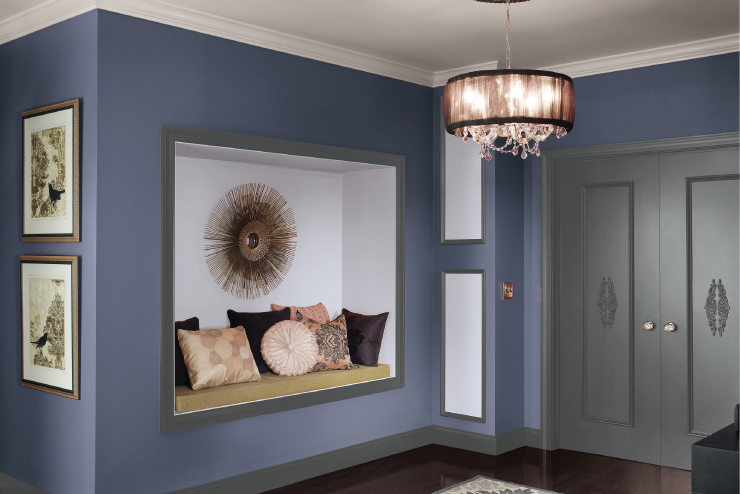 A glamorous entryway and sitting nook featuring dark blue walls and dark gray trim and double doors.