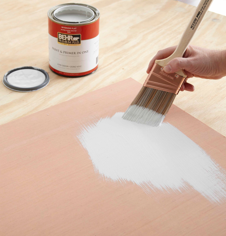 Person painting a wood board.