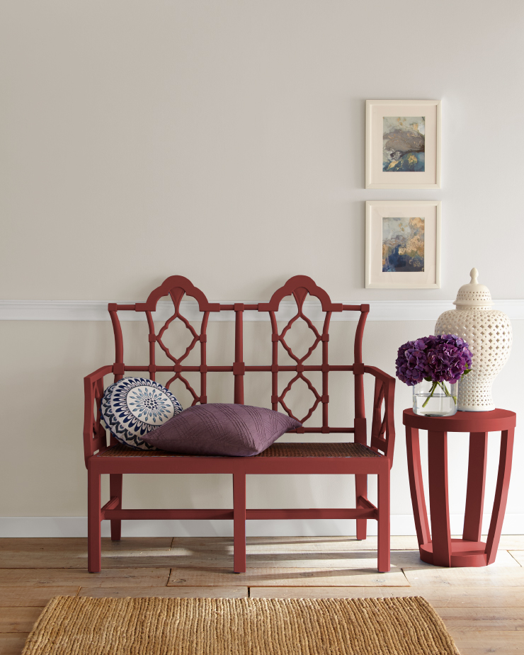 A sitting area with a red bench and small side table.