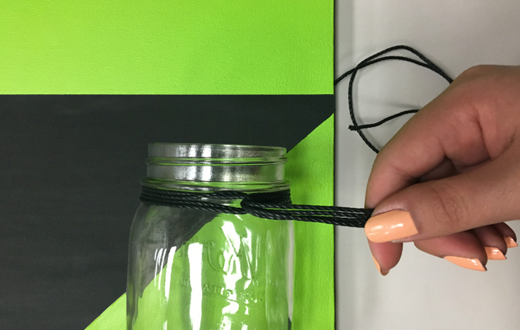  Tying a string around the glass mason jar.