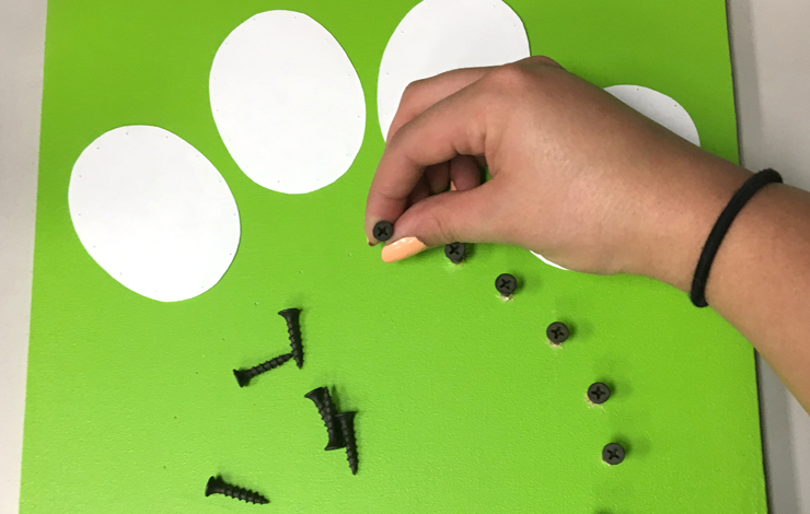 Adding screws to the green board.