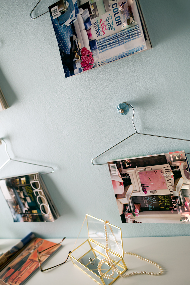 This is an up close image of the magazine wall. It shows a magazine and an up close of the jewelry box with a pearl necklace. 