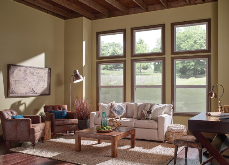 A living room with large windows against one of the walls. 