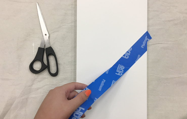 Person taping off areas of the white board that they will want to keep white.