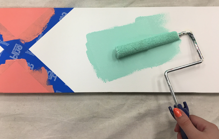 Person painting the mint color on the board.