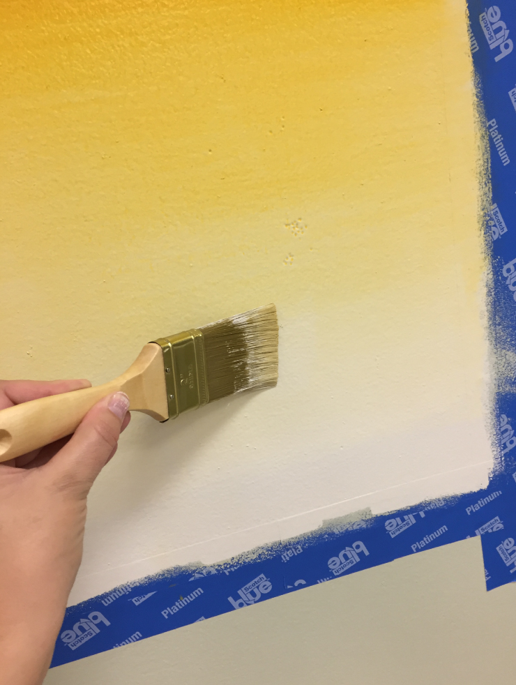 A person blending the third color with the other colors on the canvas.
