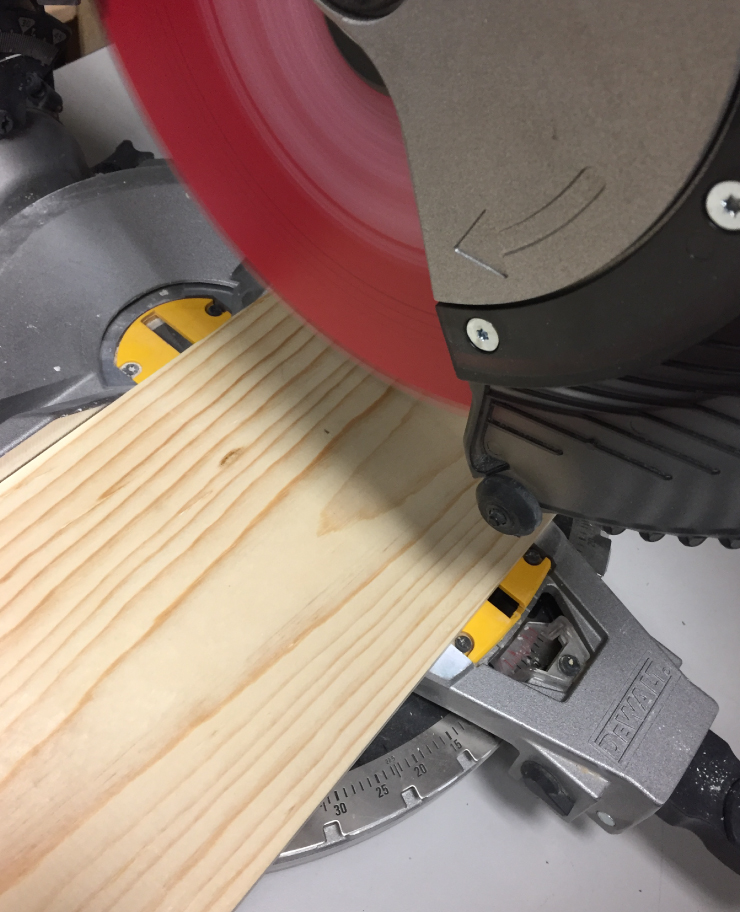 A piece of wood being cut by an electric saw.