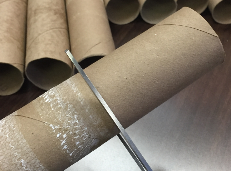 Cutting the cardboard rolls to size.