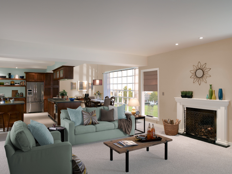 An open floor plan showing living room in the foreground, kitchen and dining in the background.