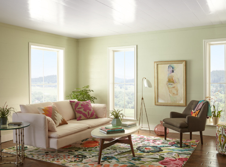 A living room with walls painted in a green color and ceiling is painted in a high-gloss white colored paint.