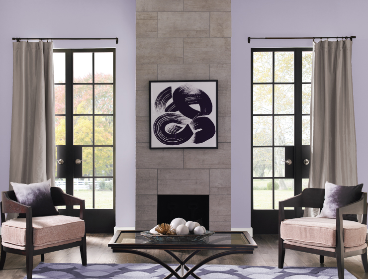 A classic living room with two large double metal and glass doors.  Tiled fireplace and walls painted in a light purple color called Fanciful. 