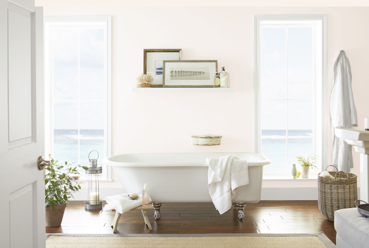 A ample pink bathroom with a lot natural light, a claw-foot tub and beautiful beach view. 