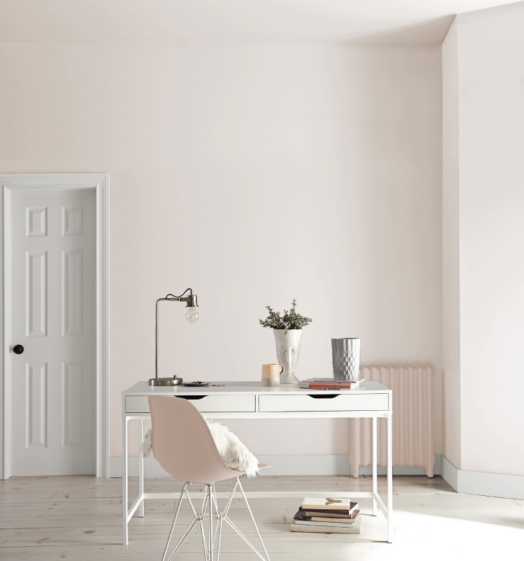 A modern, light pink and white home office with minimal decor. 