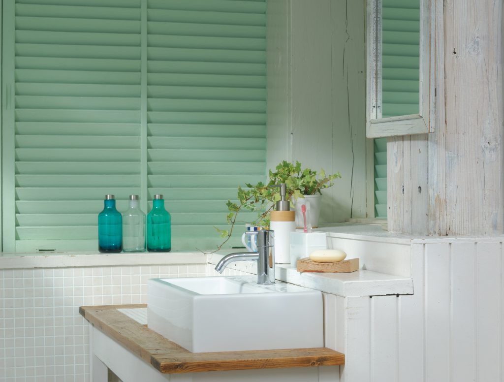 A small coastal bath with light green shutters. 