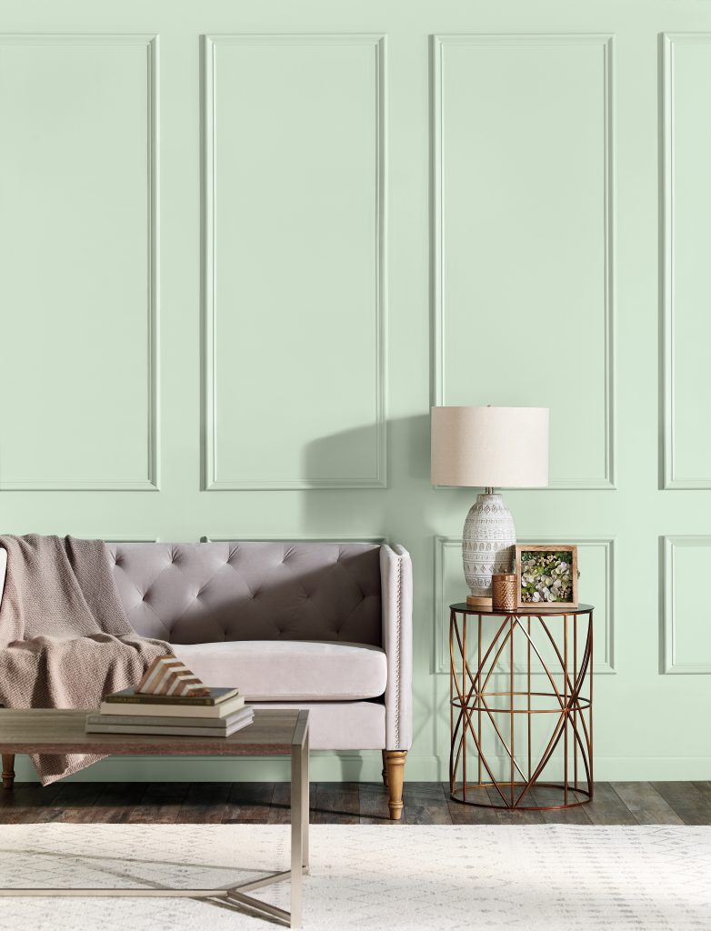 A classic yet modern paneled living room painted in light green color called Jade Mist. 