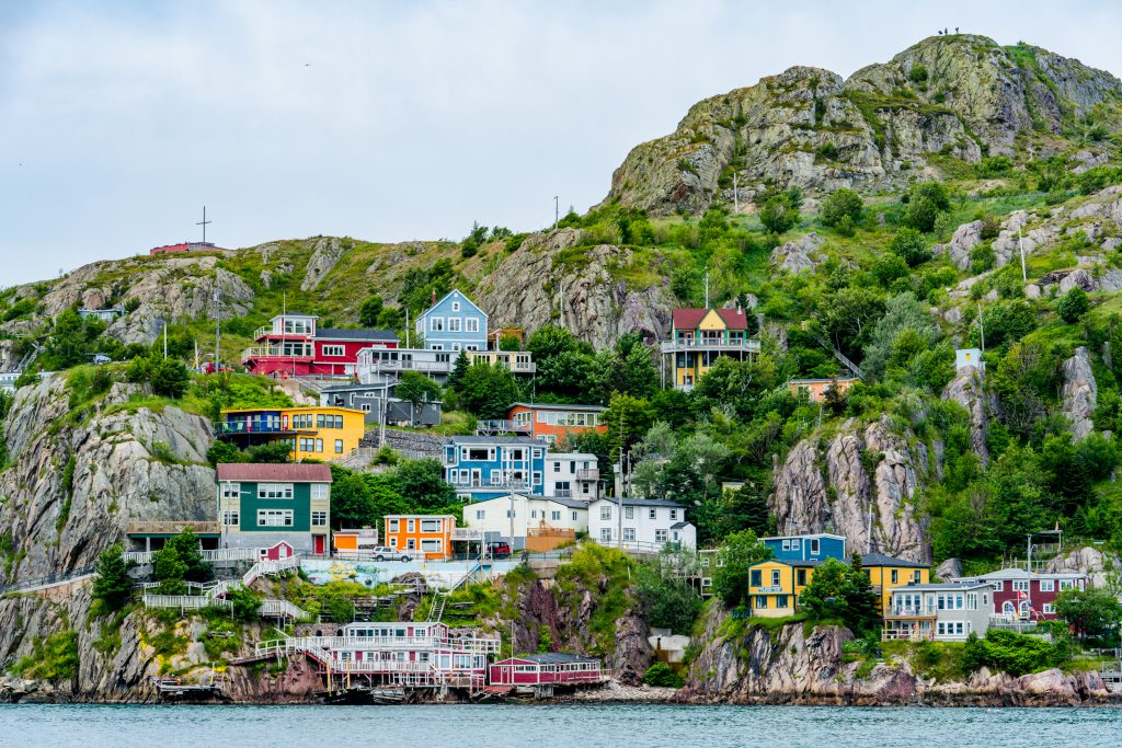 A view of St. John’s, Newfoundland showing colorful houses on a hillside along the water.
