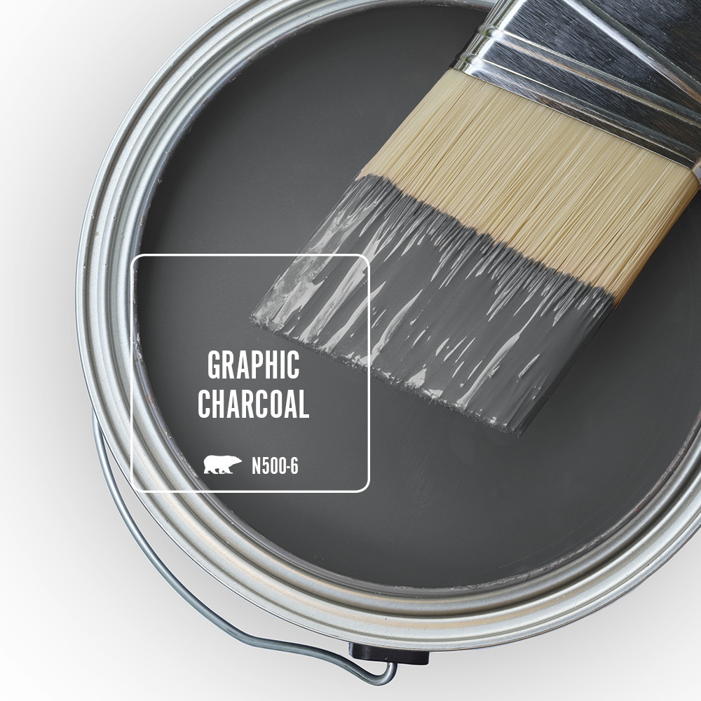 An open paint can overview featuring wet paint tinted in a dark gray color called Graphic Charcoal. 