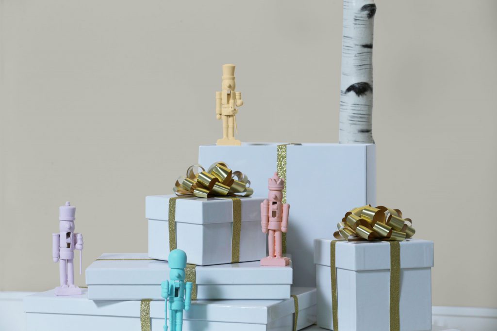 Several Christmas gifts decorated with metallic gold ribbon. 
