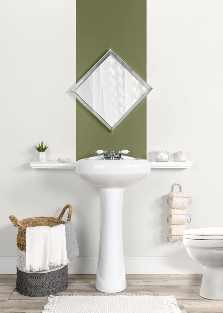 Straight-on view of bathroom. Wall is painted in Melting Icicles with a stripe down the center above the pedestal sink painted in Secret Meadow.