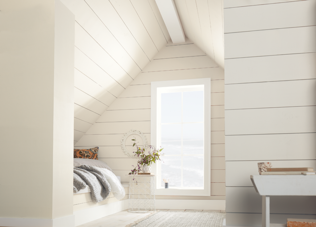 A farmhouse bedroom with walls covered in horizontal paneling, the panels are painted in white color called Painter's White.