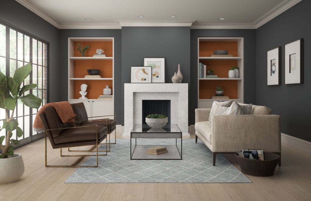 A modern living room featuring white walls dark gray color. The room is accented with an orange paint color called Rumba Orange. The overall feel of the room is modern yet cozy and welcoming.