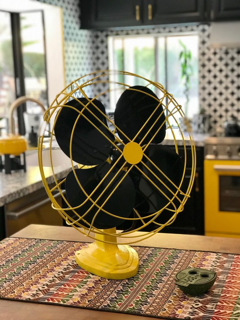 A paint over project of a vintage cooling fan, painted in bright yellow and black. 