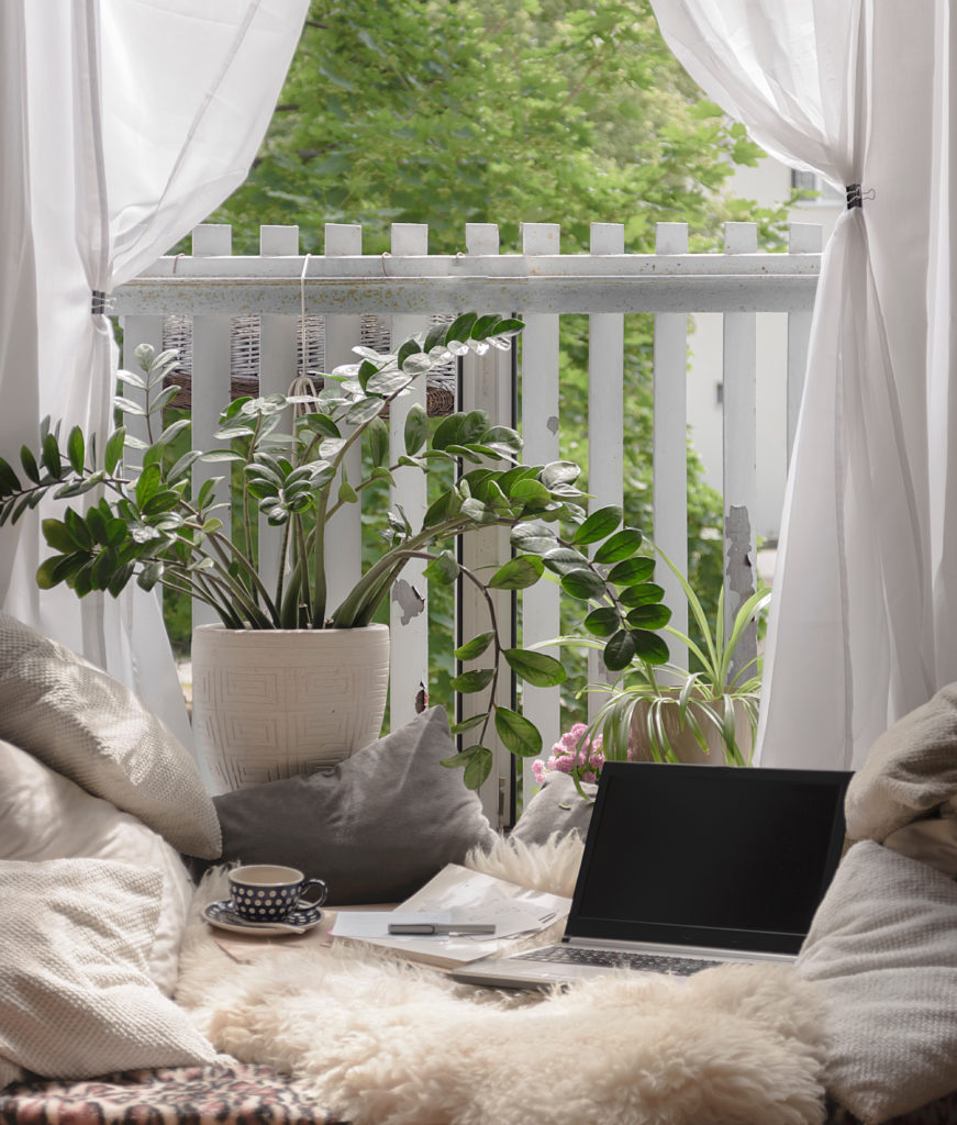 an outside area set up with blankets pillows and a laptop