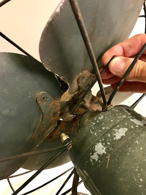 A man's hand carefully removing the fan blades. 