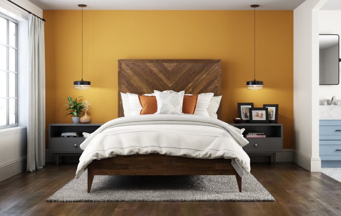 An urban rustic modern bedroom, an accent wall featuring a golden yellow color called Saffron Strands.  A modern natural wood bed with mostly white bedding.  The overall feel of the room is sophisticated and down-to-earth without feeling rustic.