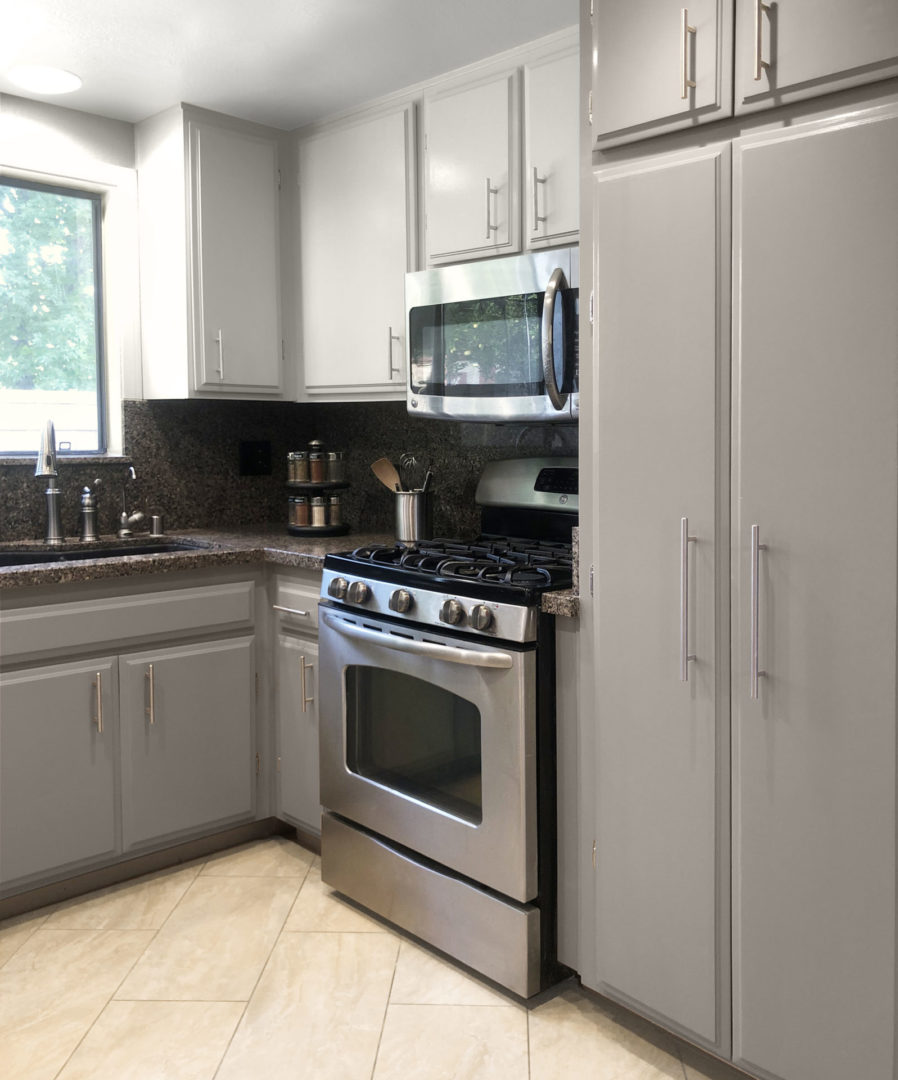 Right side of a kitchen that the cabinets have been repainted.
