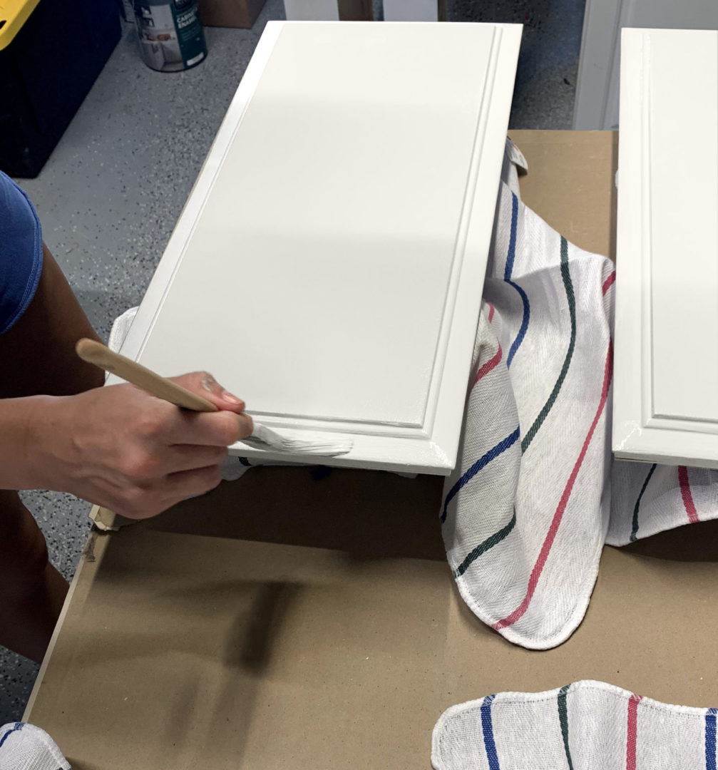 person painting cabinets.
