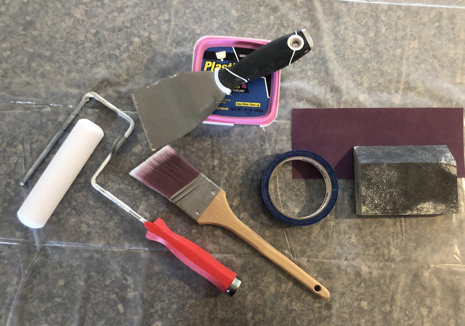 image of tools; roller, brush, spackle, sandpaper and tape.