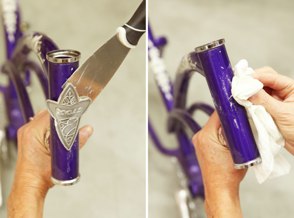 A person removing a sticker from a bike and then cleaning the residue that was left.
