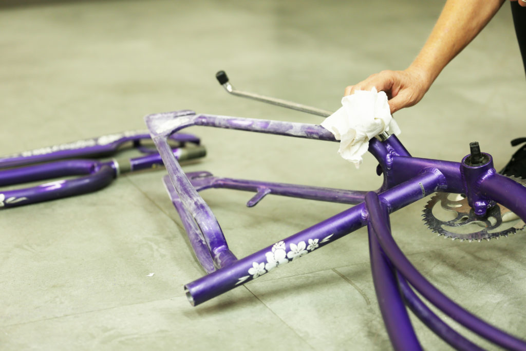 A person cleaning the sand dust from a bike.