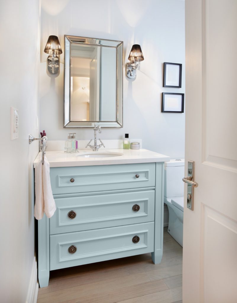 A nice small bathroom with light blue vanity, the room is painted in white paint the vanity is painted in a color called Dayflower. 