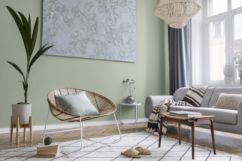 Interior design of living room at modern home with stylish furniture. The room feel well lit with natural light and the walls are painted in a mid-tone green called Jojoba.  