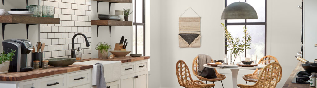 Farmhouse style Kitchen with a small dining table. Walls are painted in the color Smoky White.