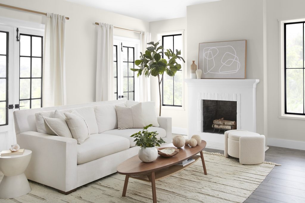 A stylish and inviting living room space painted in Blank Canvas.  Hues of brown, gray, and black accentuate this otherwise white living room, making it feel inviting.