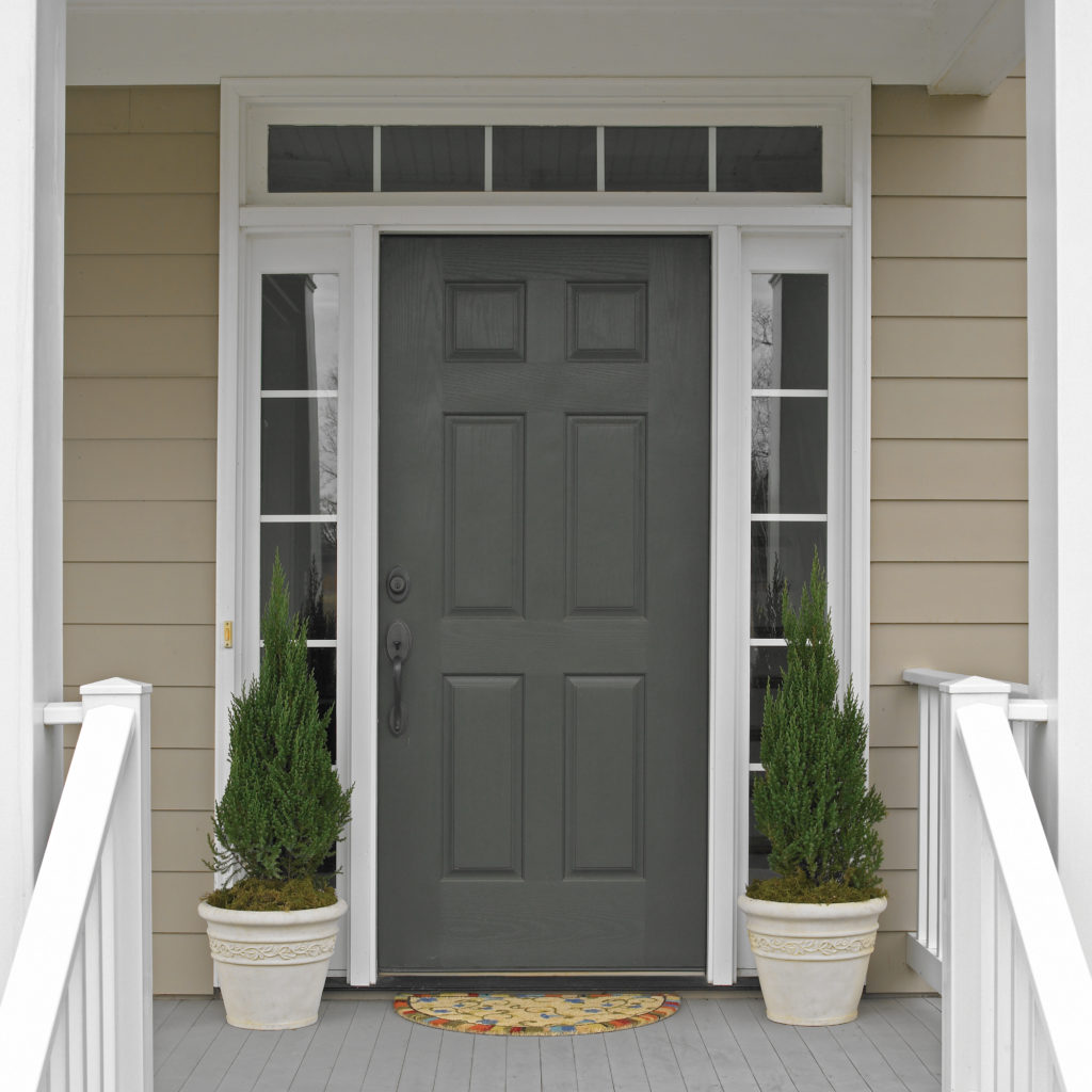 A light beige colored house with a dark charcoal colored door.