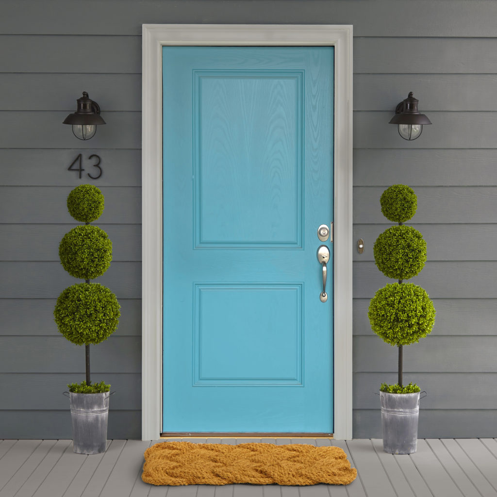 A housed painted in a dark charcoal color with a bright blue painted door.